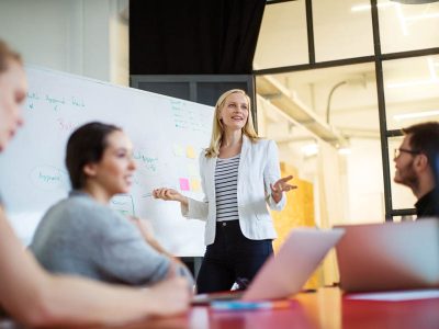 Young businesswoman giving presentation on future plans to her colleagues at office