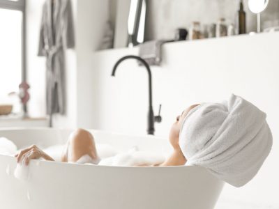 Young attractive woman relaxing in bathtub