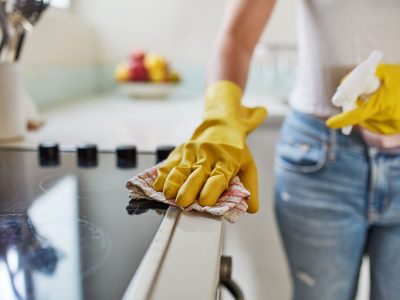 Cropped shot of a woman cleaning a kitchen counter at home